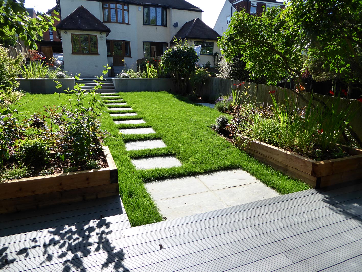 A carpet of lawn sweeps down to the garden room. Bordered by a vibrant planting scheme designed to attract wildlife and pollinators.