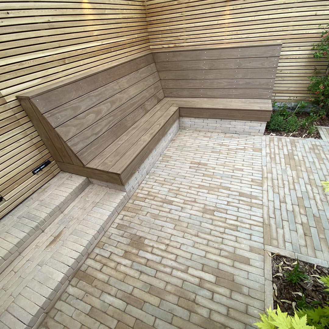 Bespoke reclining bench, larch screening, clay paver brick steps and paving create a minimalist Scandinavian style courtyard.