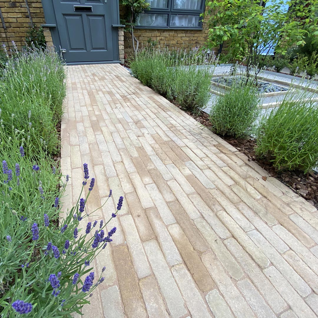Decorative stones and focal Amelanchier tree framed inside concentric brick squares.