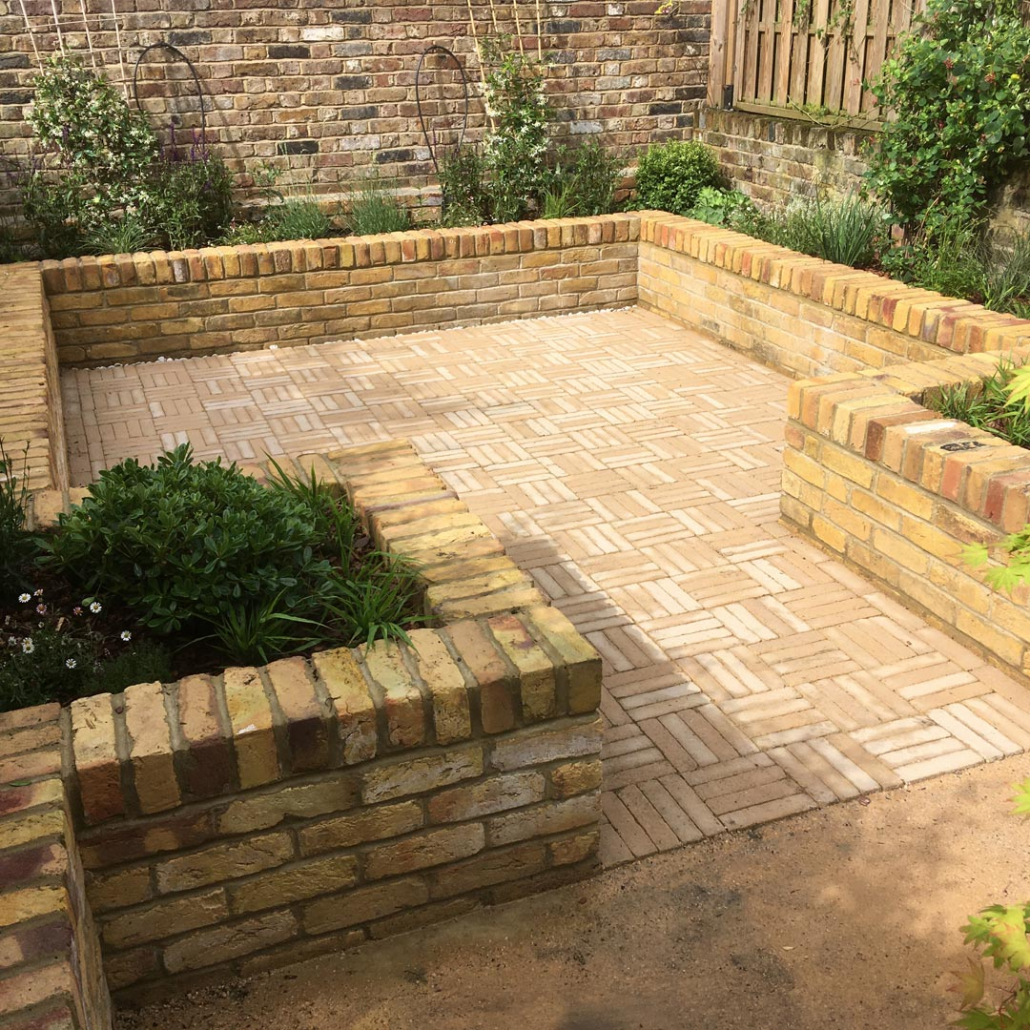 Aureum Vande Moortel clay-pavers laid in a basket-weave pattern, define this area as the main entertaining space in this family garden.