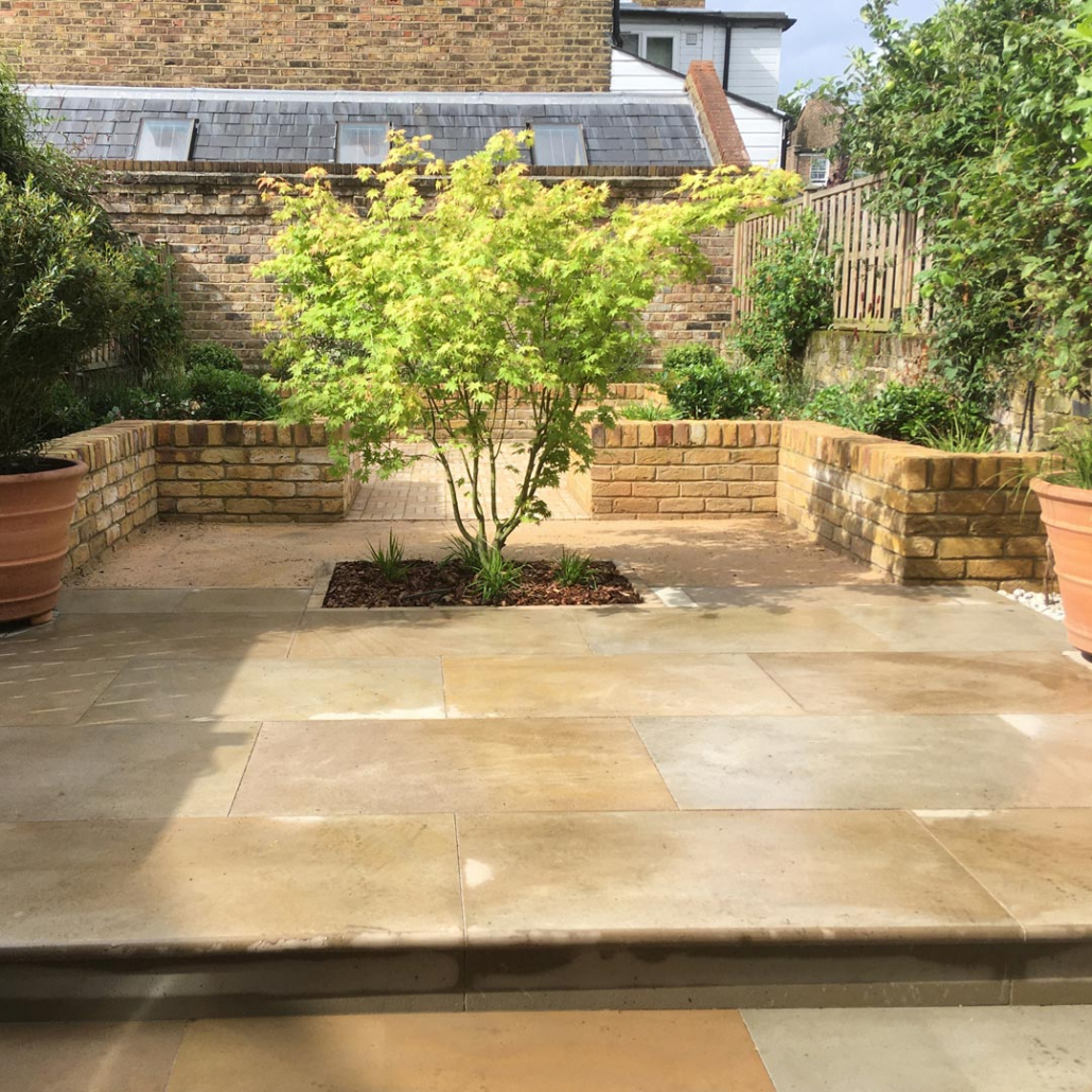 Buff sandstone paving in tones that compliment the bricks and self-binding gravel help to unify the colour palette chosen for this design.