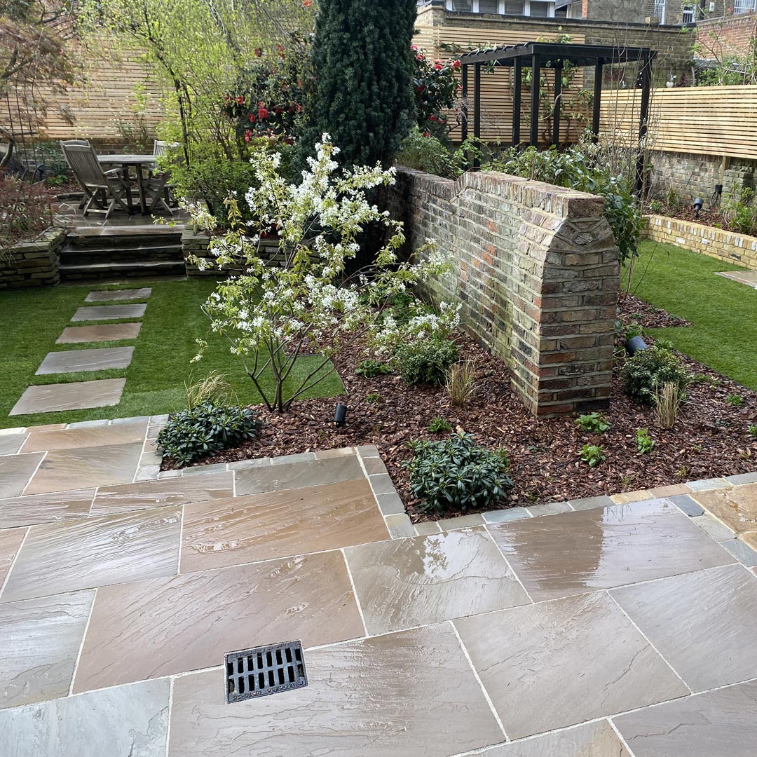 Sandstone setts edge the perimeter of both gardens and shows how two separate spaces have now become one.