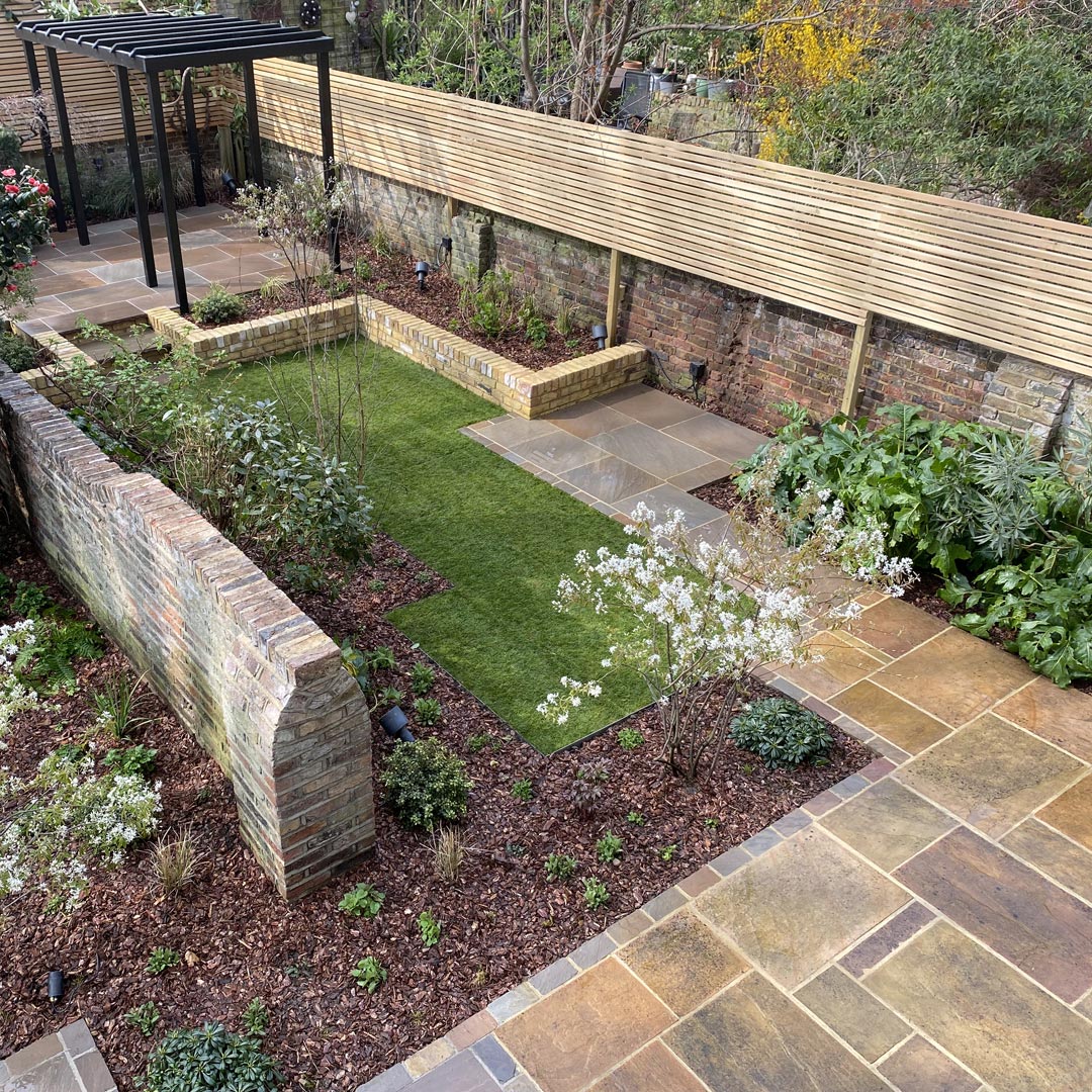 The laying pattern and warm colours of the sandstone paving softens the expanse.