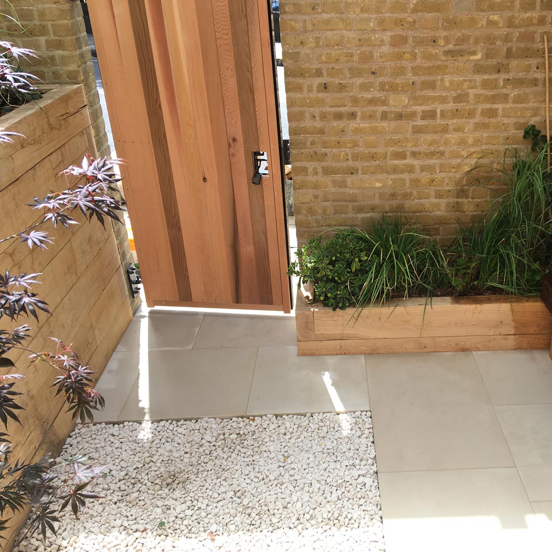 A stylish cedar clad gate leads you to the street. By using light materials this small courtyard instantly feels more spacious.