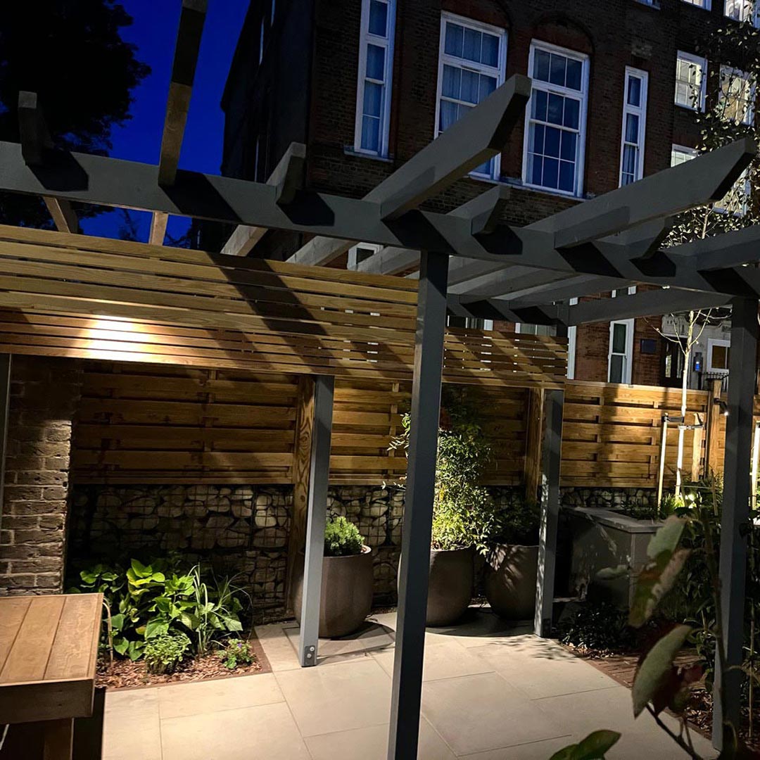 Soft wood fencing panels and rock filled gabions have been used to separate the old caretaker’s house from the converted Victorian school.