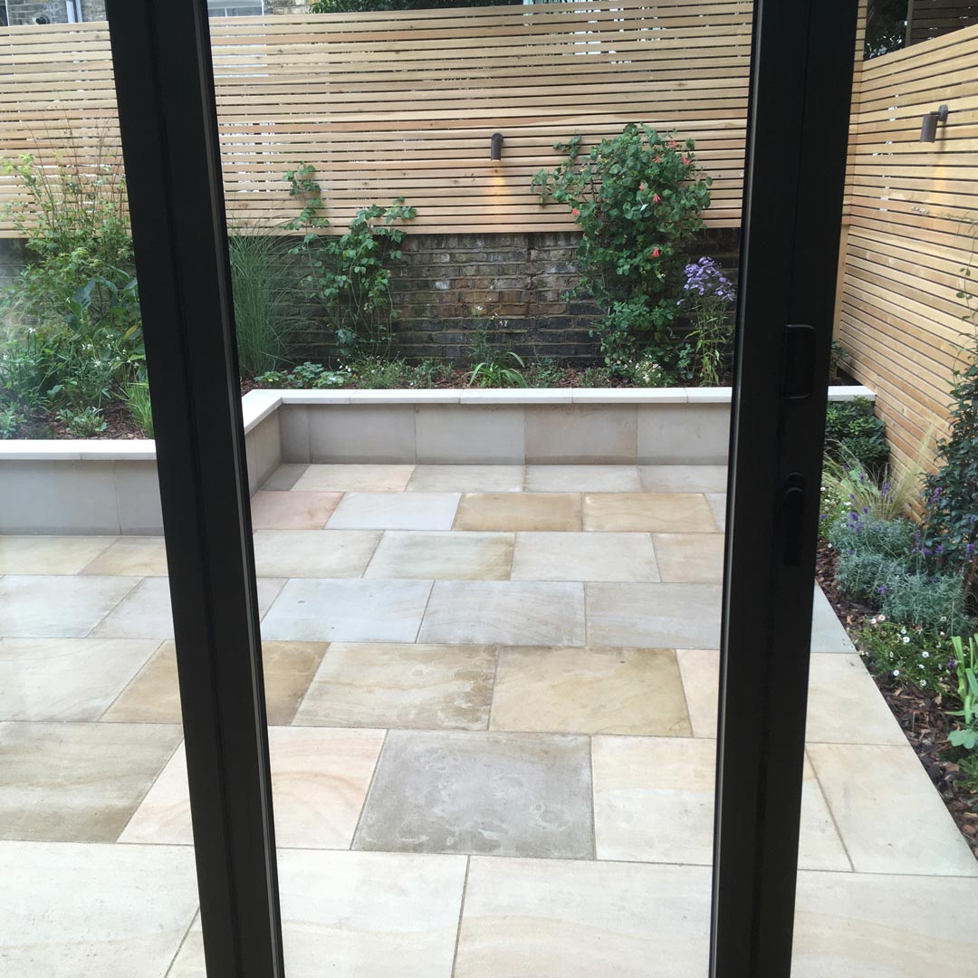 A view out from the kitchen shows the main patio area laid with ‘Harvest' sawn sandstone.
