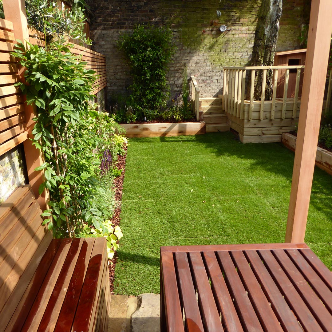 Wisteria sinensis has been trained to climb up the pergola post and onto the slatted roof.