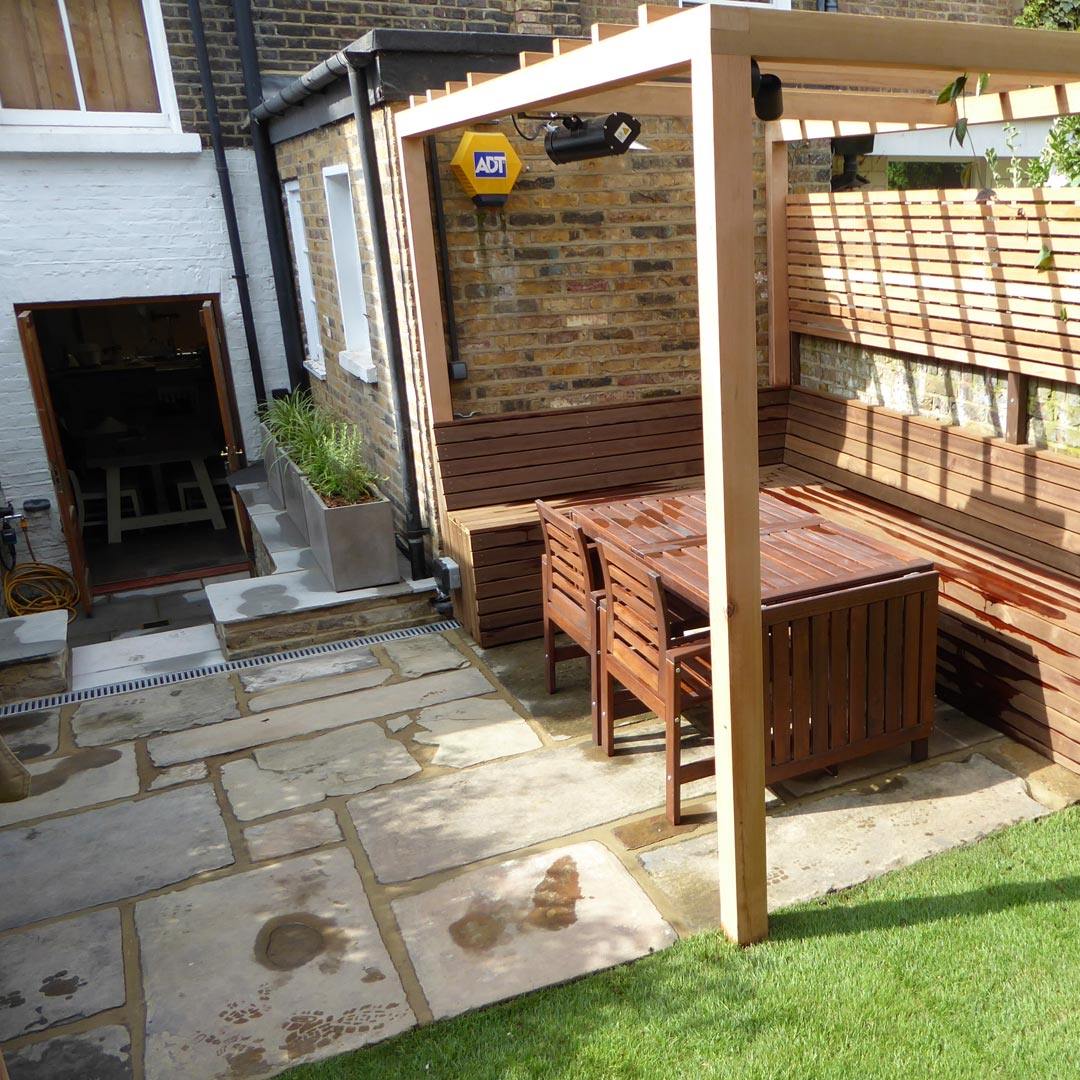 In the main entertaining space, the patio is reclaimed Yorkstone paving. The pergola has been fitted with outdoor lighting.