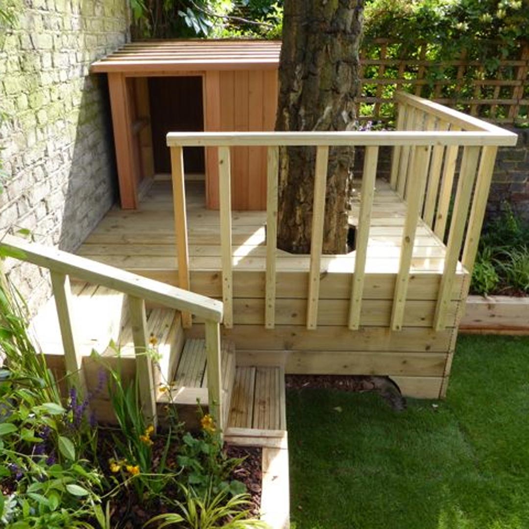 Side view of den showing the colourful planting of perennials such as; Trollius, Geum, Crocosmia and Salvia.