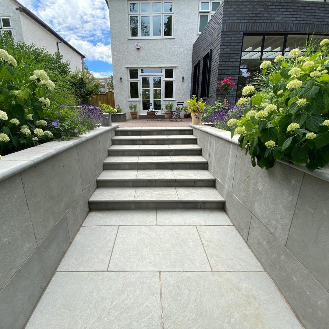 Grey limestone steps take you from the terrace into the lower part of the garden. Either side flagged with the stately presence of hydrangea ’Strong Annabelle’.