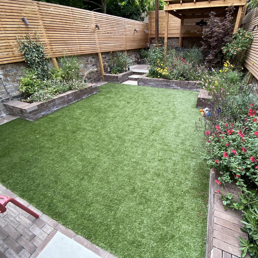 A large lawn for young children’s play and colourful plants in raised beds for them to explore.