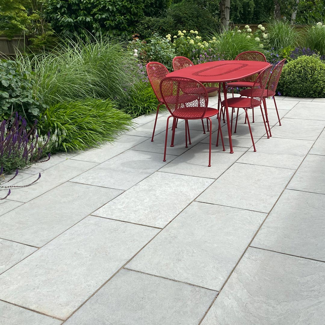 Raised retaining beds with herbaceous plants and shrubs such as; Miscanthus, Hakonechloa, Salvia, Paeonia and Hydrangea soften the Grey Limestone paving of the main terrace.