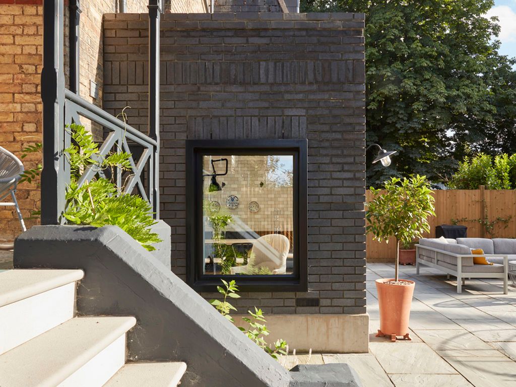 The grey riven sandstone patio contrasts well with the grey bricks of the new extension.