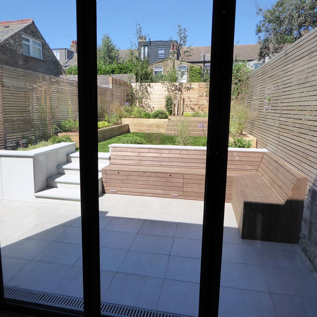 View from the bi-fold doors show the level change in the garden. 3 Silver birch trees create a focal point at the back of the garden.