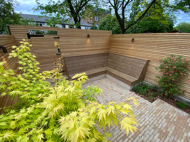 This contemporary rear garden makeover creates a light, open and beautiful space for entertaining and features a stunning Acer specimen tree and L-shaped bench.