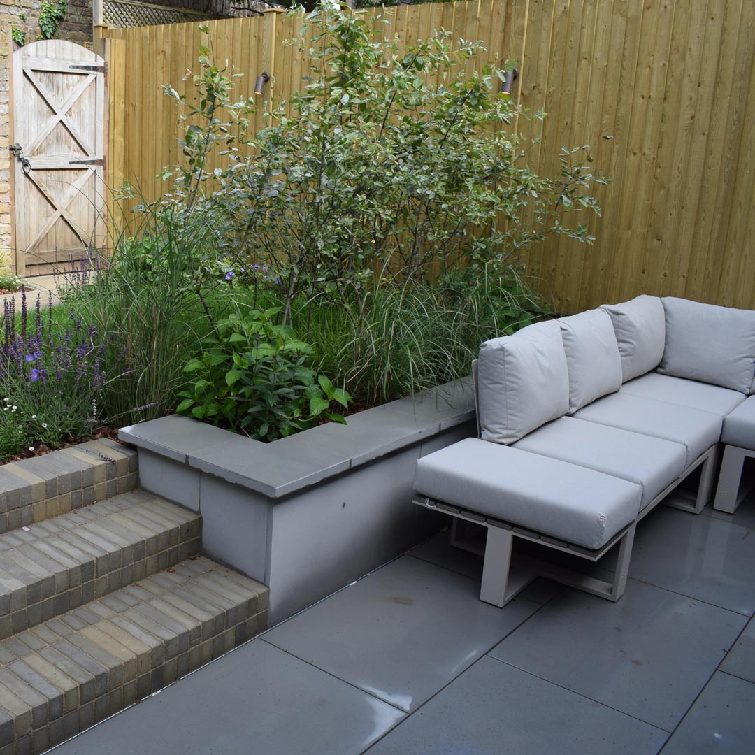 Grey sawn sandstone paving was used for the patio its colour depicted in the grey flecks of the Salvia pavers.