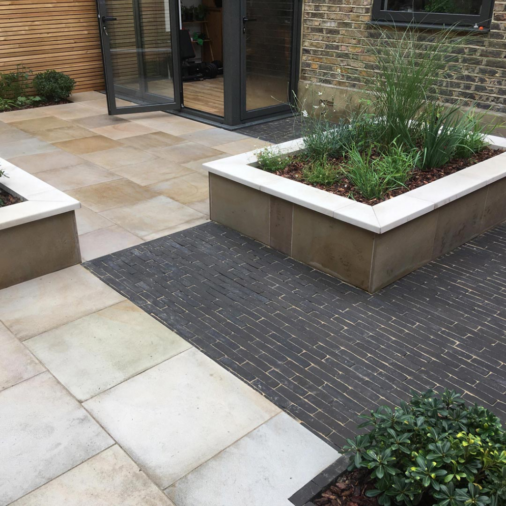 Raised beds clad in sawn sandstone and Vande Moortel ‘Titan' pavers divide the garden into zones.