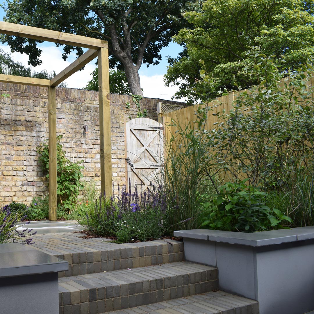 Retaining beds clad in grey sawn sandstone with pencil-edge copings.