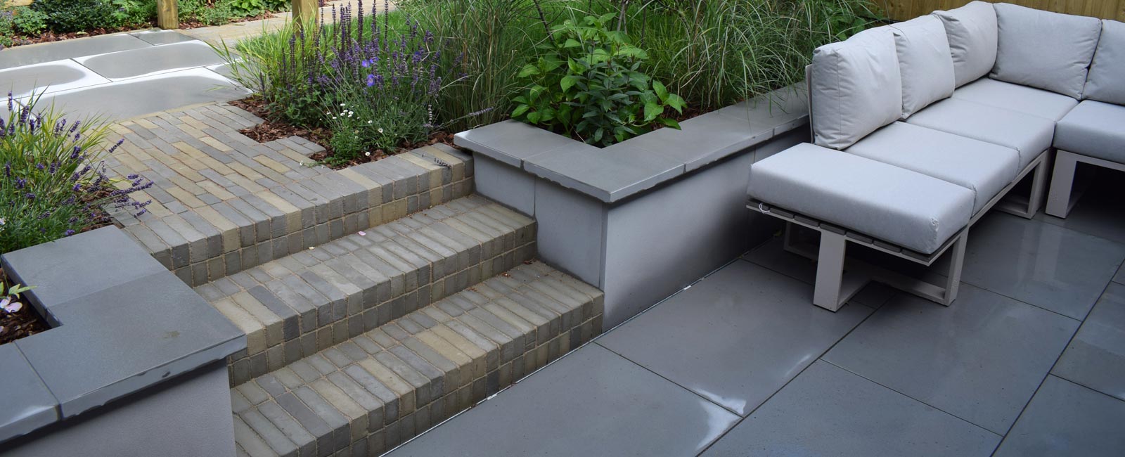 A patio area was designed and built at the back of the house, close to the kitchen, and features a large outdoor sofa.