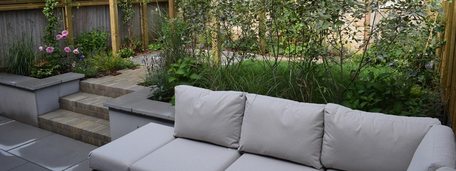 An urban contemporary/country courtyard style garden design in Islington, North London (N1), featuring different zones with hard & soft landscaping and a soft, romantic planting scheme.