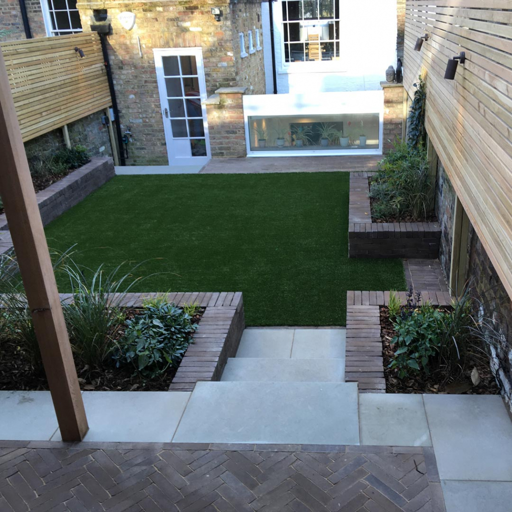 A simple design for a young family. A lawn for play, raised clay paver beds and grey sandstone steps lead to the dining area.