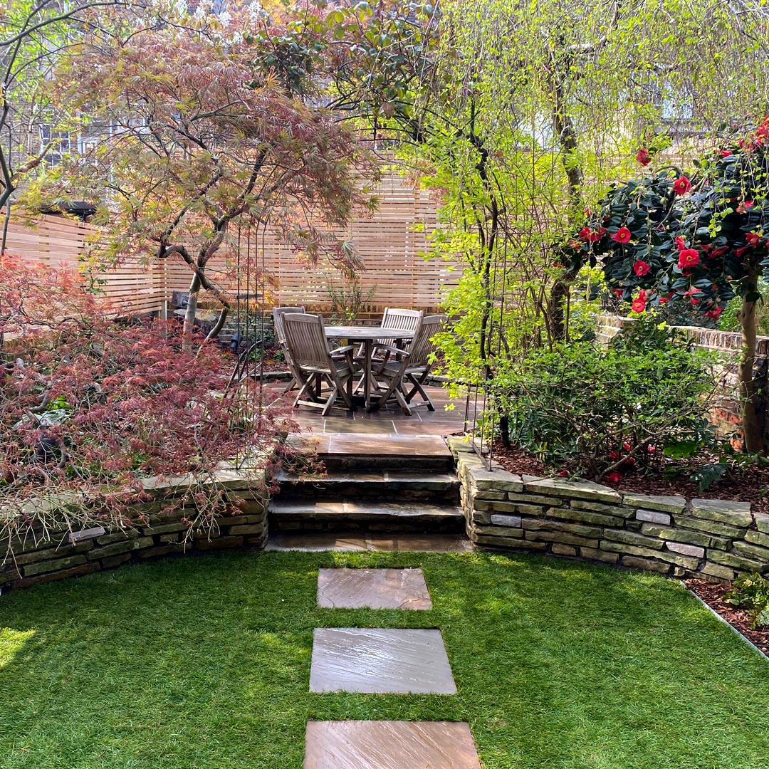 A direct path leads to a rose arch that frames the entrance to one of the back patios.