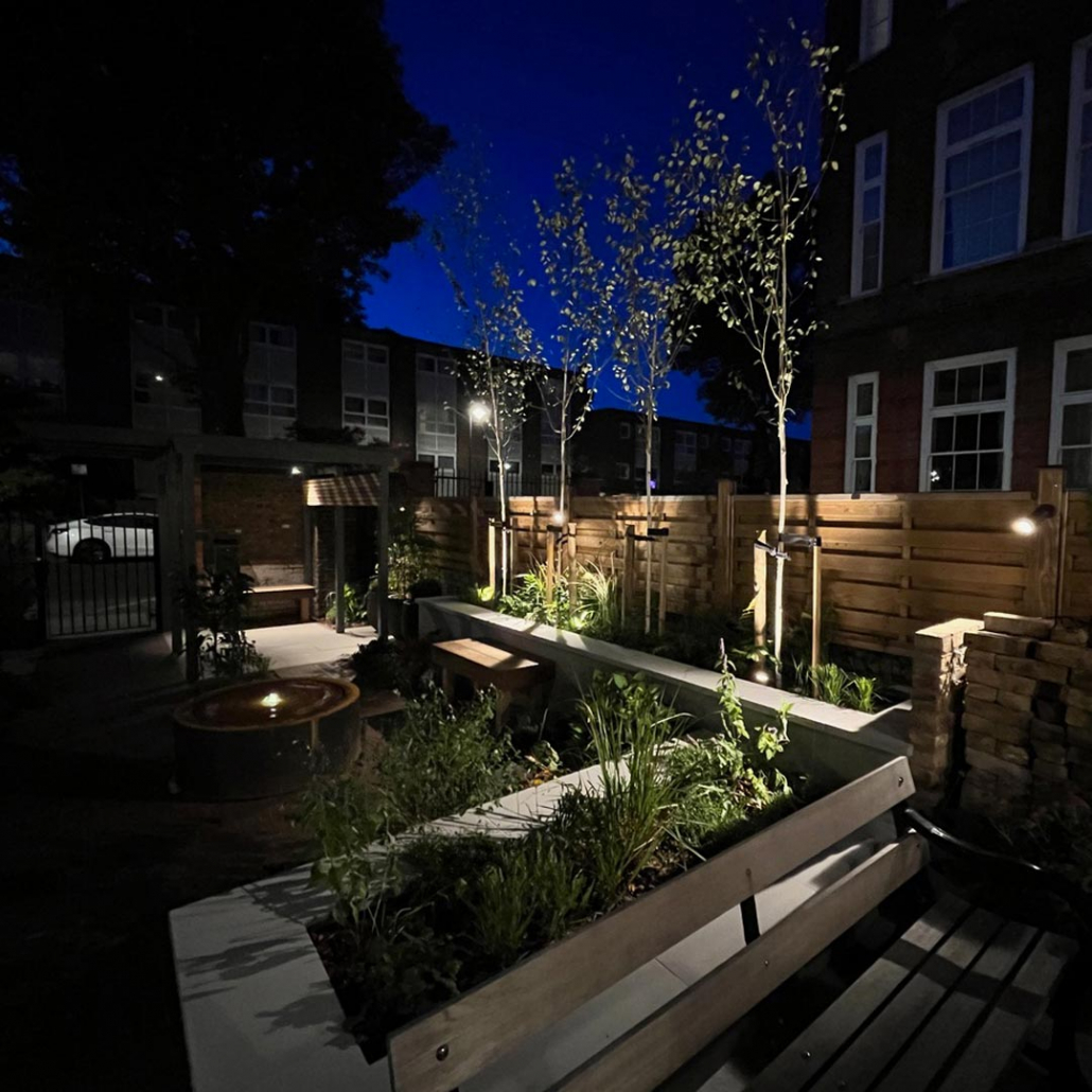 This noise-reducing redesign features extra privacy for relaxation and includes a pergola, water feature, irrigation, raised beds, lighting & plants that will attract wildlife.