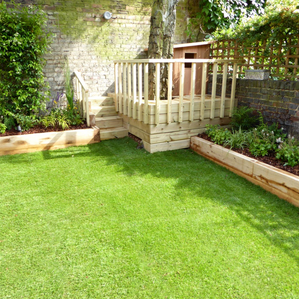Raised flower beds and custom-made steps lead to the raised play deck for children, cleverly integrating an existing mature silver birch tree into the platform.