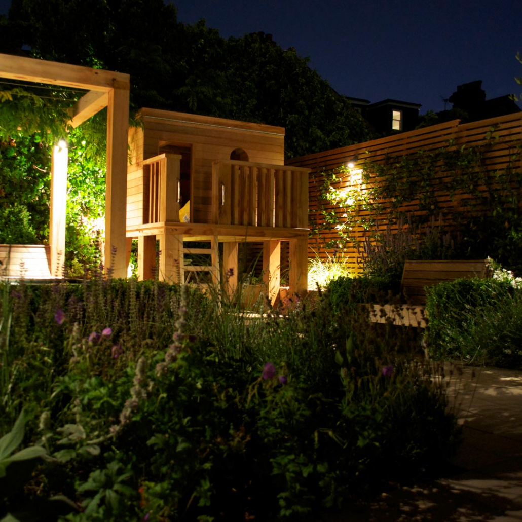 In the garden at night. Lights illuminate the space for outdoor entertainment.