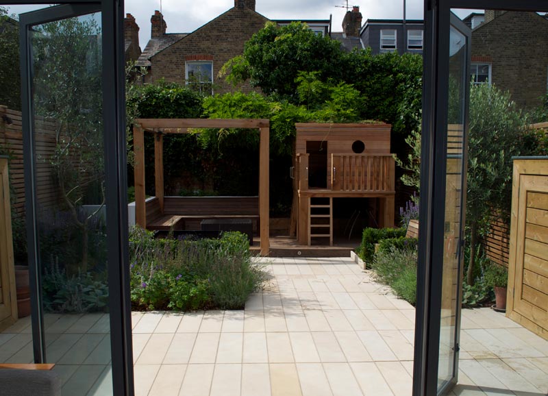 A contemporary, multi-award-winning garden design in Kew TW9, with children's play den, entertaining space, built-in storage & more.