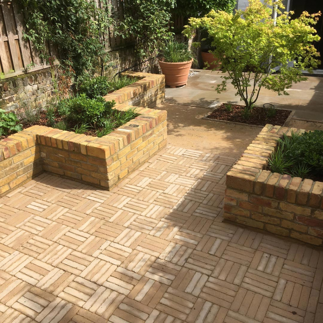 The hard landscaping is softened with specimen trees, shrubs, mature climbers, grasses, and perennials.