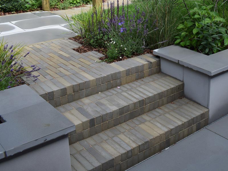 A patio area was designed and built at the back of the house, close to the kitchen, and features a large outdoor sofa.