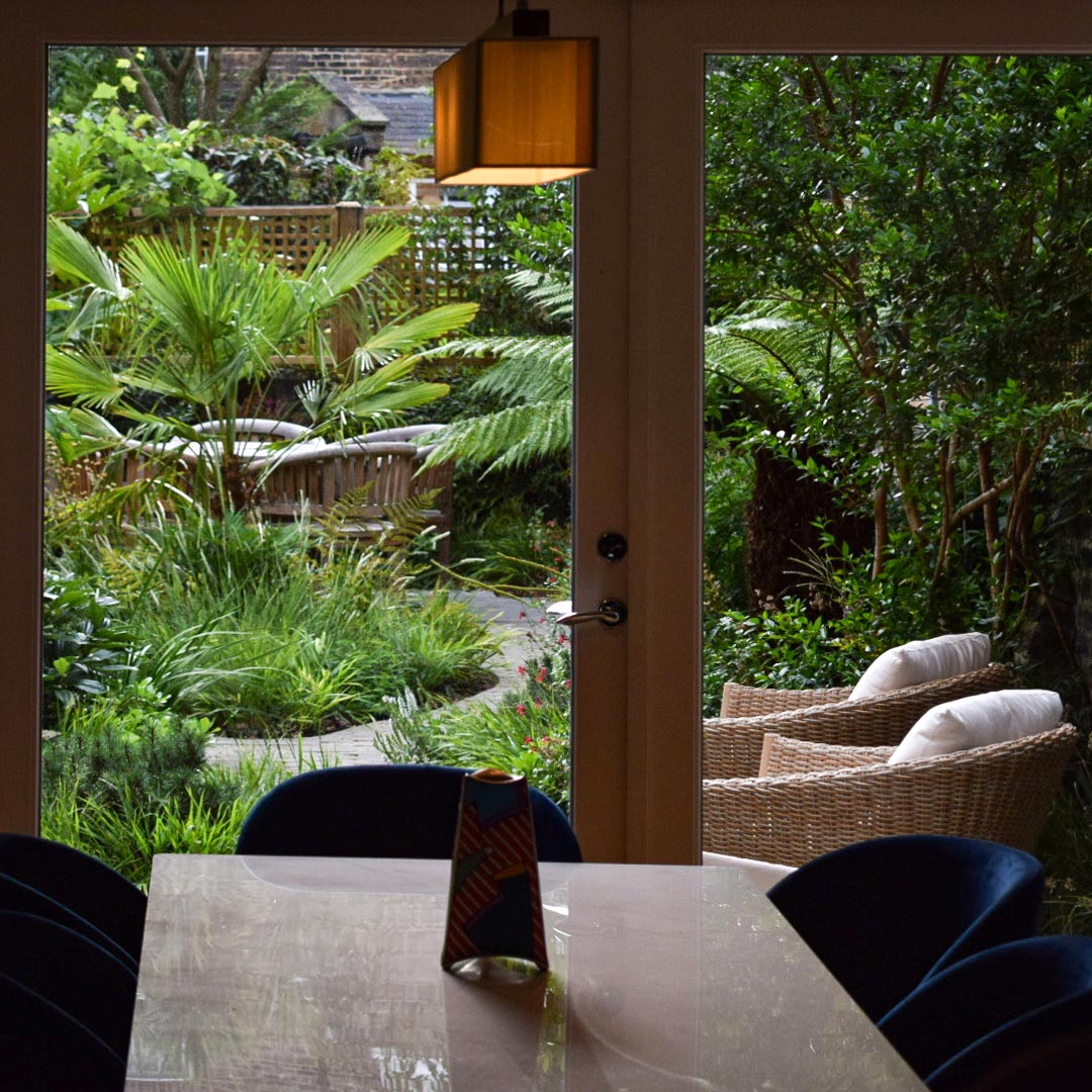 Tree ferns and a multi-stem Myrtus tree create a stunning view from the dining room.