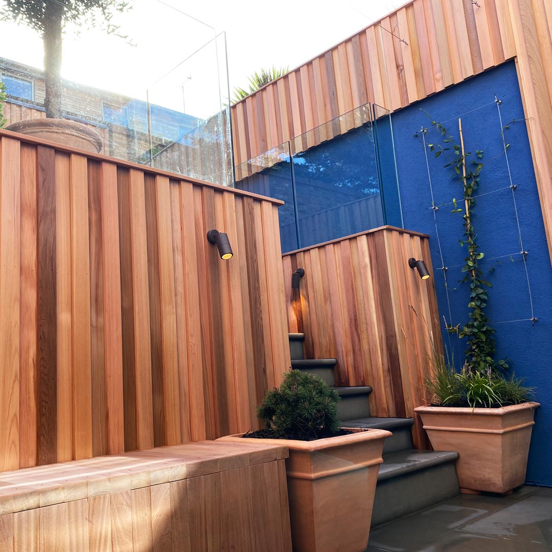 The original retaining wall has been clad with the warm tones of cedar wood bringing a more naturalist vibe