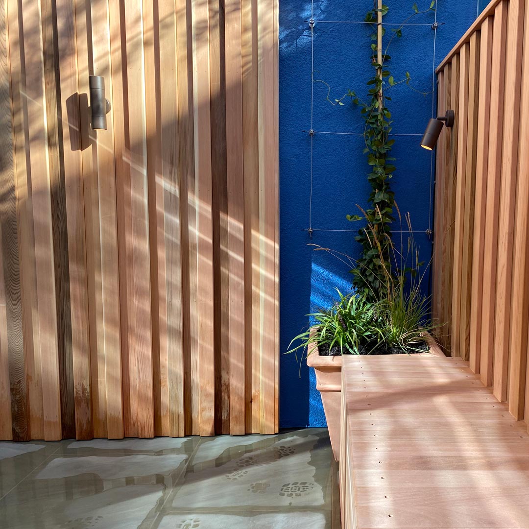 Natural stone paving compliments the cedar bench and wall cladding.