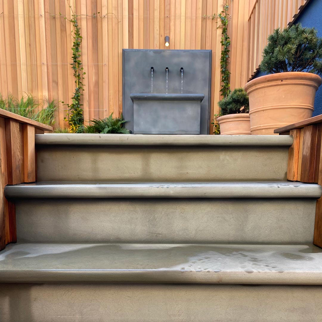 Heath sawn sandstone steps lead up to the main entertaining space and a zinc water trough.